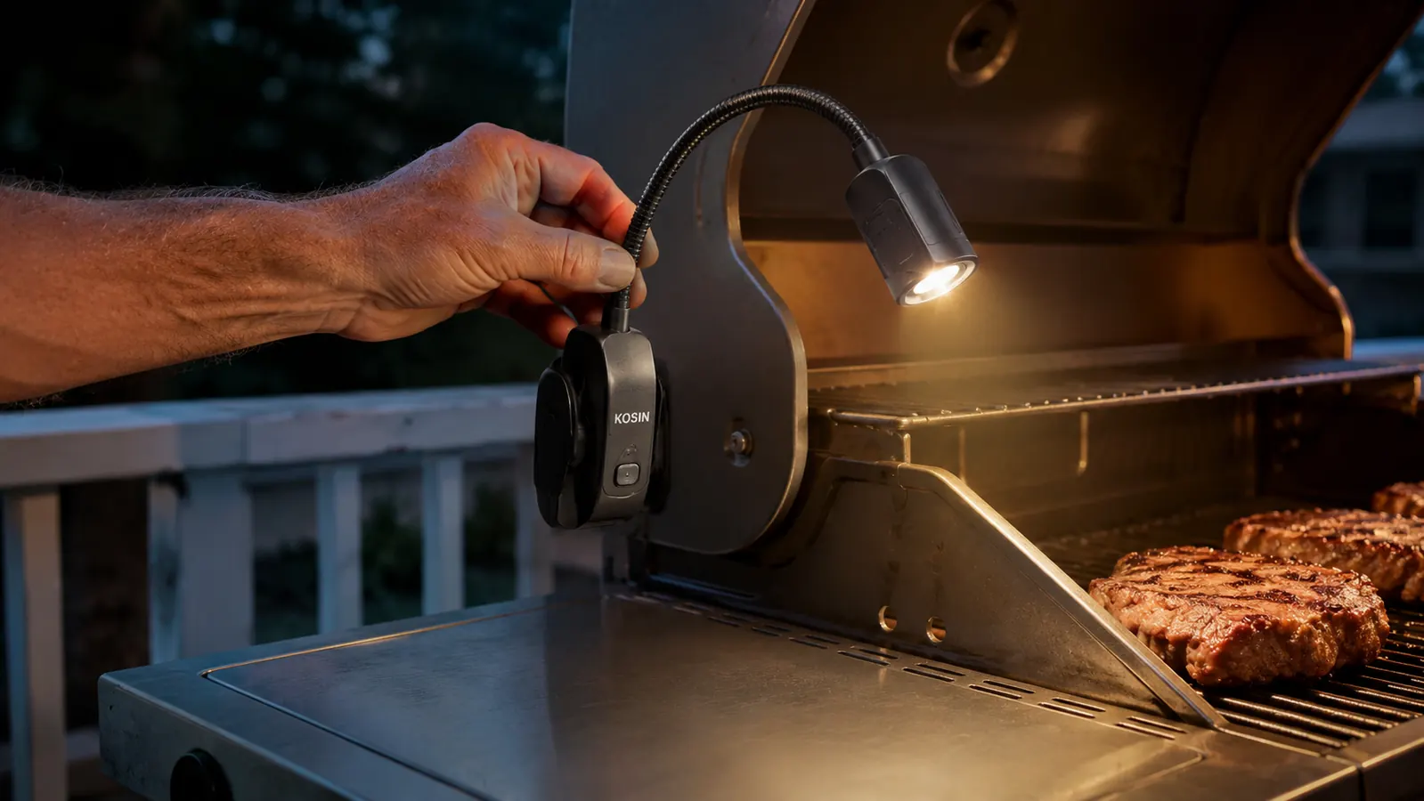 Close-up of a hand adjusting the gooseneck arm of a magnetic grill light mounted on a grill's side shelf